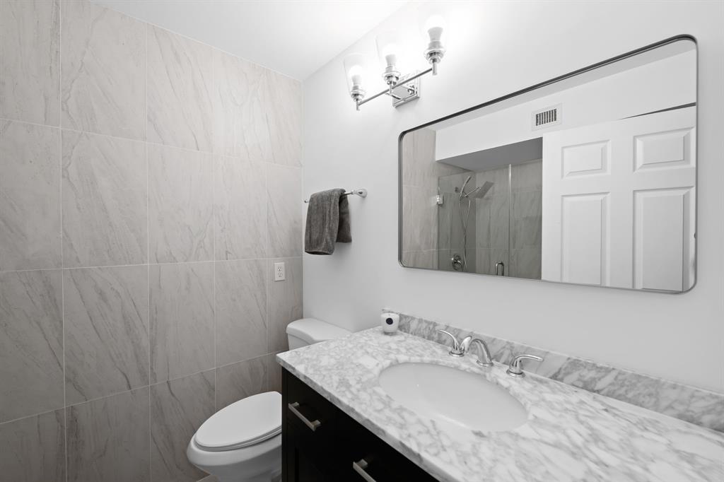 5298 Buckhead Circle, Unit 1040 Boca Raton, FL 33431 - Photo 11 of 25 a bathroom with a granite countertop sink toilet and mirror