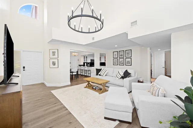 a living room with furniture a mirror and a flat screen tv