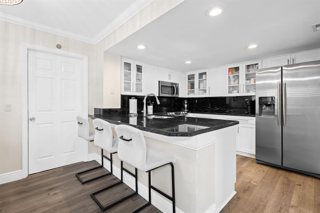 5298 Buckhead Circle, Unit 1040 Boca Raton, FL 33431 - Photo 8 of 25 a kitchen with stainless steel appliances granite countertop a sink a stove a refrigerator and island with wooden floor
