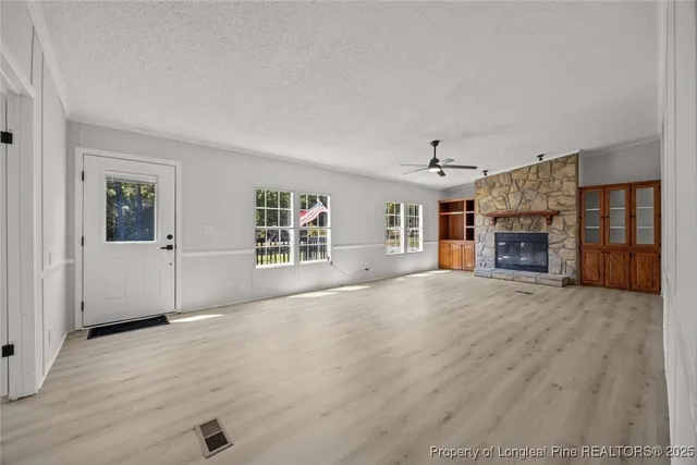 an empty room with windows and fireplace