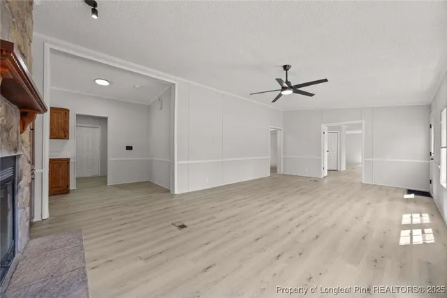 a view of a livingroom with wooden floor and a ceiling fan