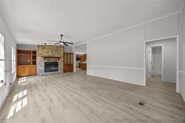 an empty room with wooden floor and fireplace