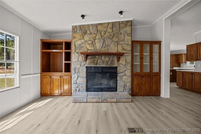 a living room with a fireplace furniture a ceiling fan and a window