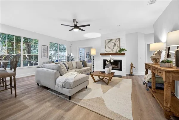 a living room with furniture a fireplace and a large window