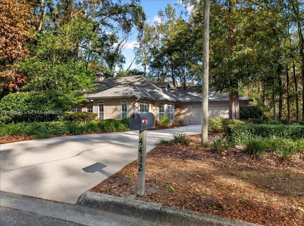 4412 Southwest 101 Drive Gainesville, FL 32608 - Photo 24 of 52 a view of a patio with table and chairs under an umbrella
