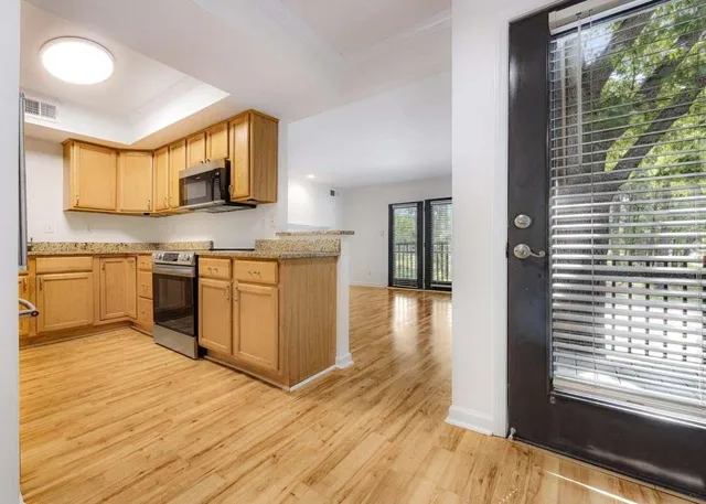 a kitchen with stainless steel appliances granite countertop a stove top oven a sink and a microwave