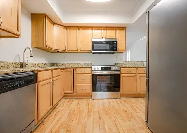 a kitchen with stainless steel appliances a stove a sink and a microwave