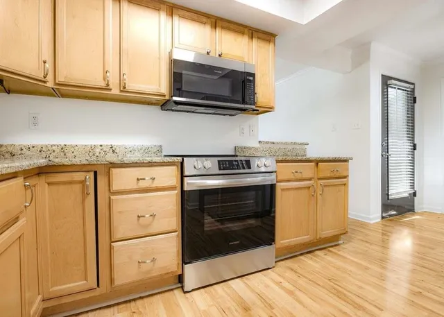 a kitchen with stainless steel appliances granite countertop a stove a microwave and a sink
