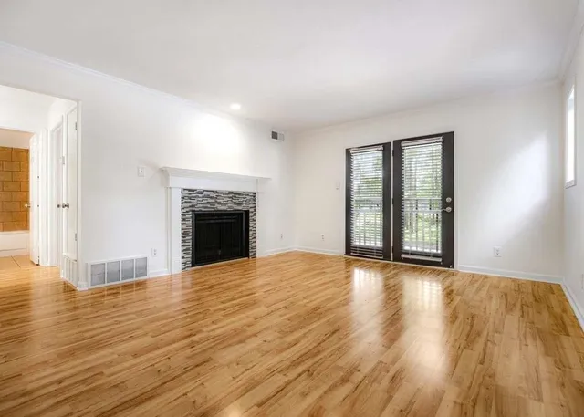 wooden floor fireplace and windows in an empty room