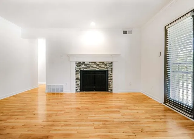 a view of an empty room with window and fireplace