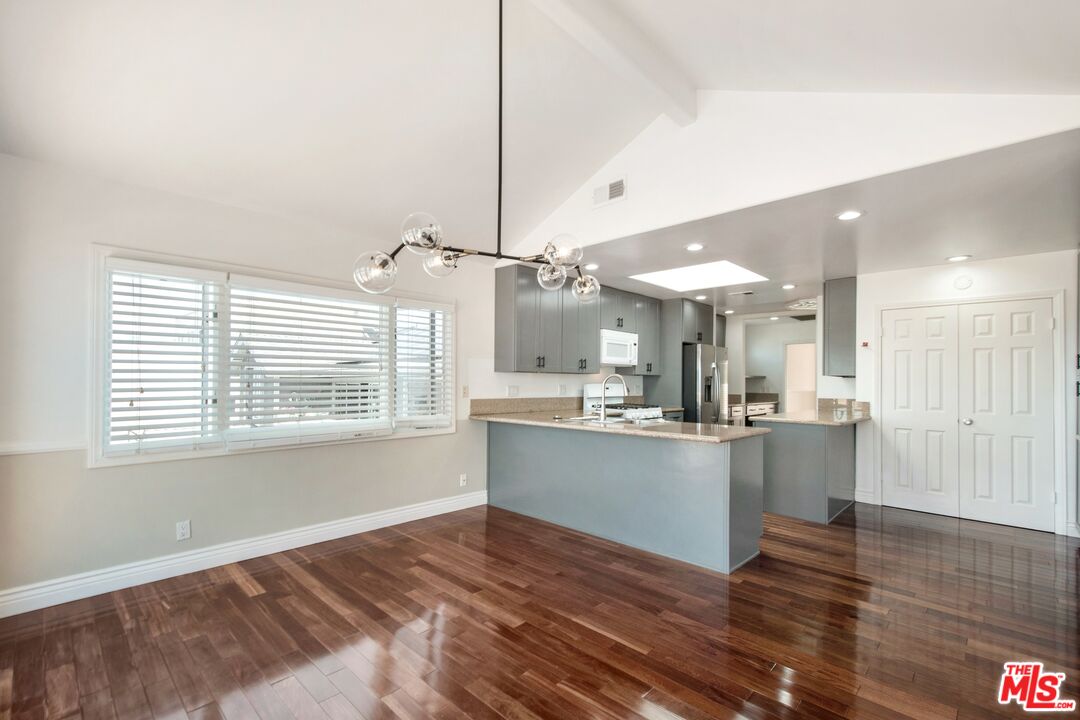 217 Fowling Street Playa del Rey, CA 90293 - Photo 17 of 51 a kitchen with stainless steel appliances kitchen island wooden floors and white walls