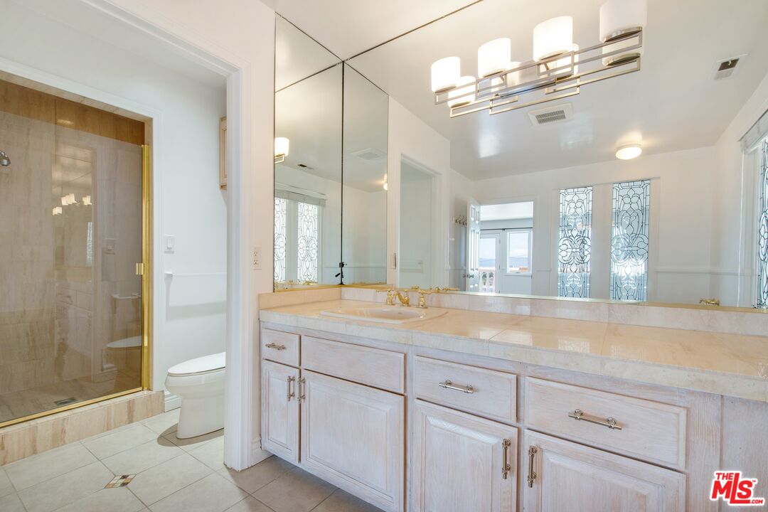 217 Fowling Street Playa del Rey, CA 90293 - Photo 34 of 51 a spacious bathroom with a granite countertop sink a toilet a mirror and shower
