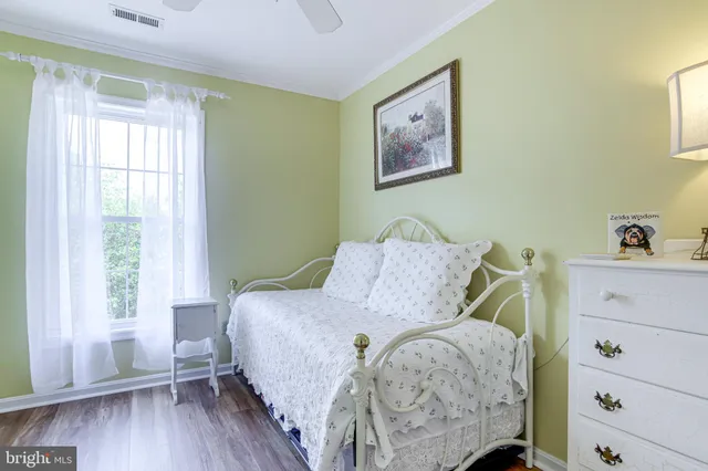 a bedroom with a bed and a painting on the wall