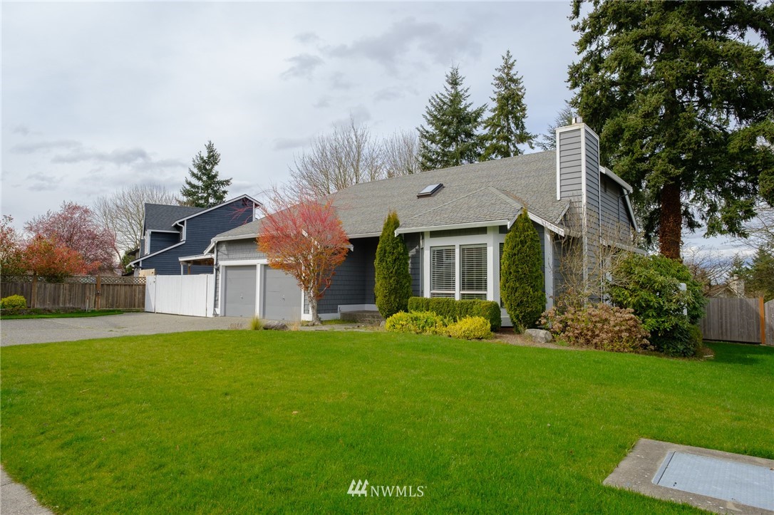 2211 236th Street Southeast Bothell, WA 98021 - Photo 22 of 26 a front view of a house with a garden and trees