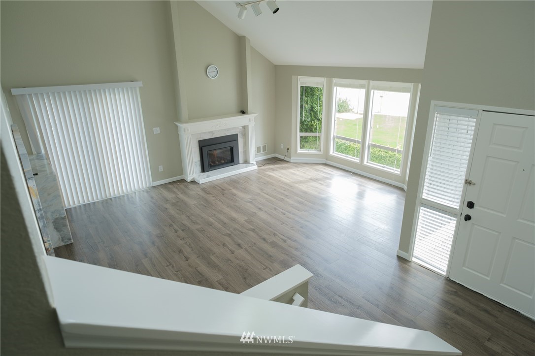 2211 236th Street Southeast Bothell, WA 98021 - Photo 4 of 26 a view of an empty room with wooden floor and a window