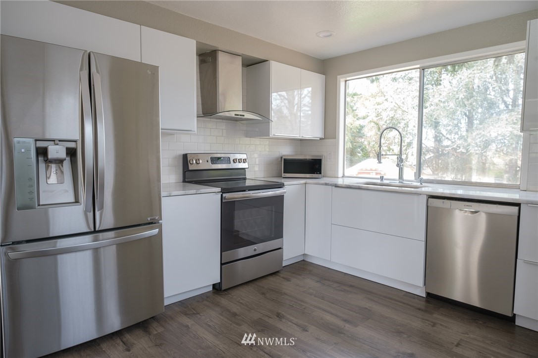2211 236th Street Southeast Bothell, WA 98021 - Photo 5 of 26 a kitchen with stainless steel appliances white cabinets and a window