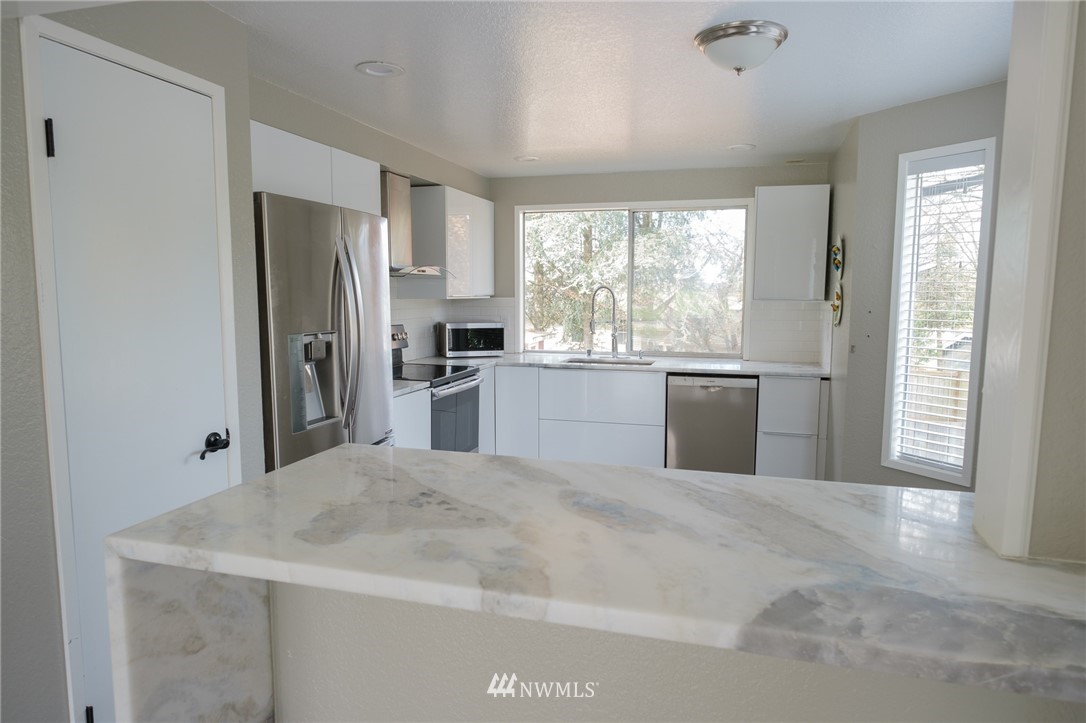 2211 236th Street Southeast Bothell, WA 98021 - Photo 7 of 26 a kitchen with stainless steel appliances granite countertop a refrigerator sink and stove