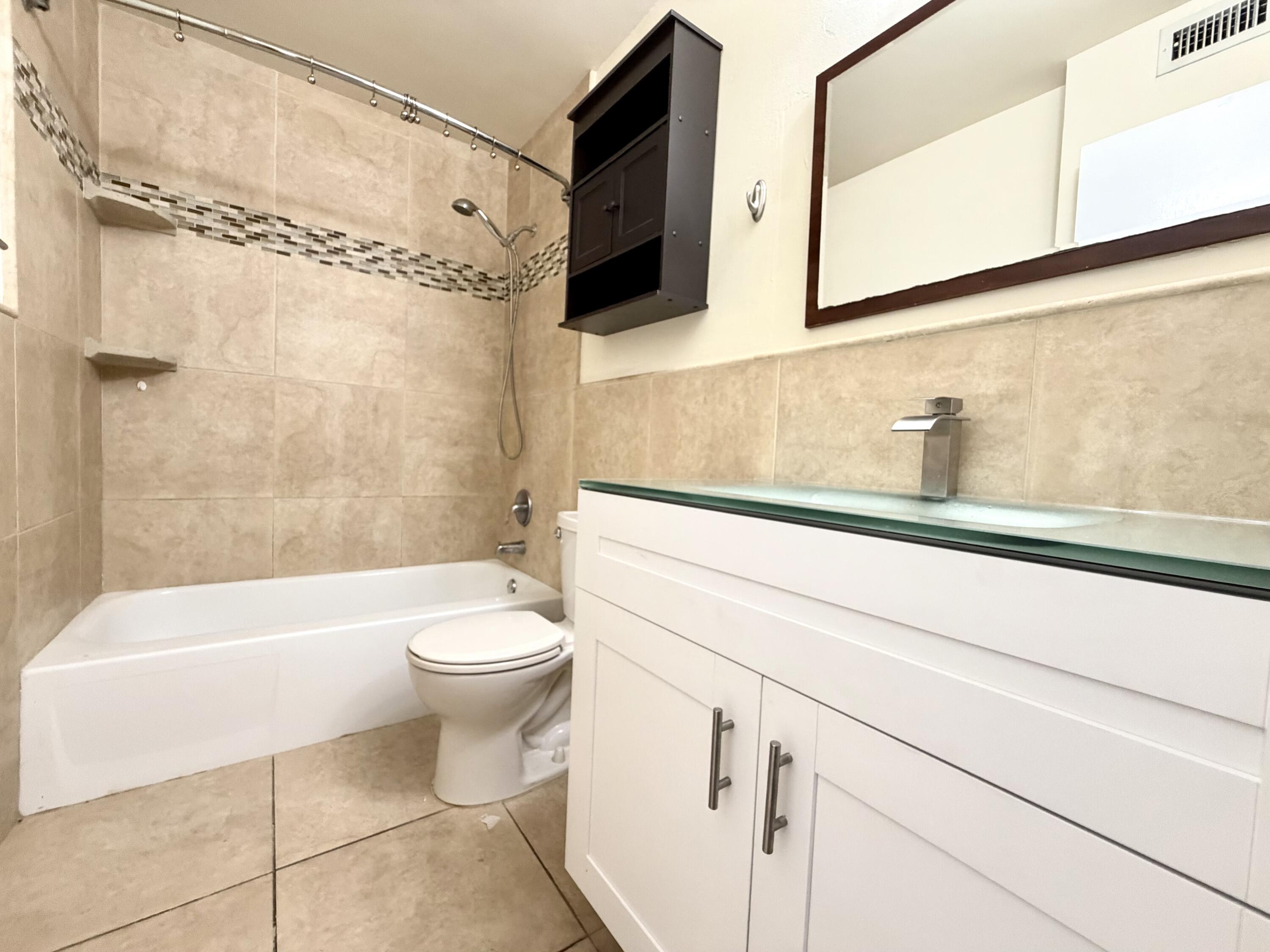 5811 Northeast 14th Road, Unit 4 Fort Lauderdale, FL 33334 - Photo 23 of 29 a bathroom with a sink a toilet and a bathtub