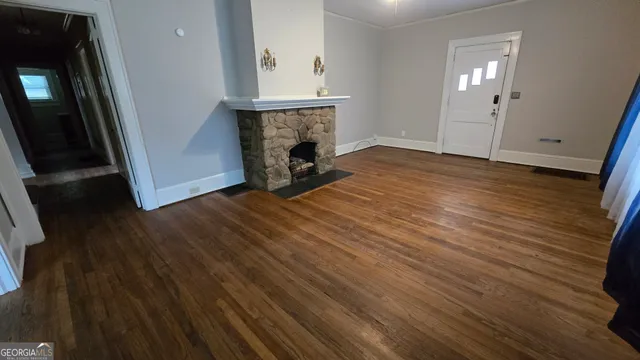 a view of a livingroom with wooden floor and a fireplace