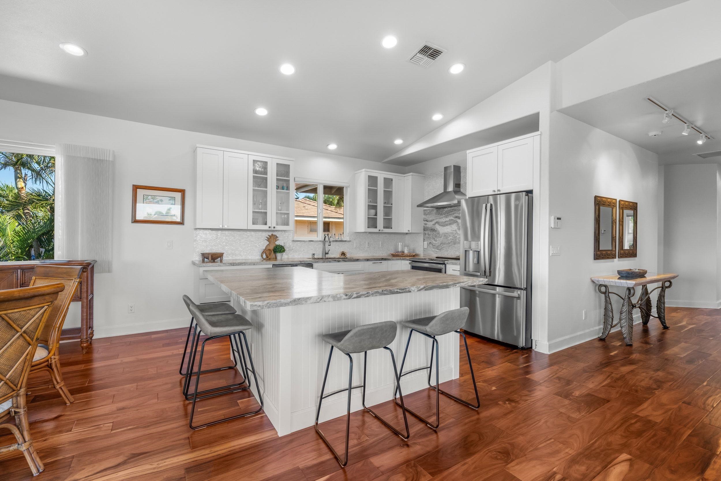 125 Kahana Makai Road Lahaina, HI 96761 - Photo 4 of 46 a kitchen with stainless steel appliances granite countertop a dining table chairs refrigerator and sink