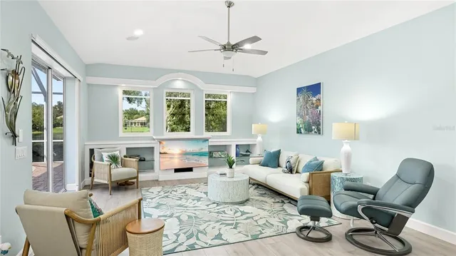 a living room with furniture a fireplace and large windows