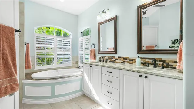 a bathroom with a granite countertop sink and a bathtub