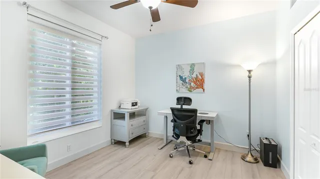 a view of a workspace with furniture and a window