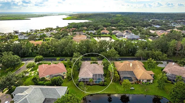an aerial view of a house with a garden and lake view