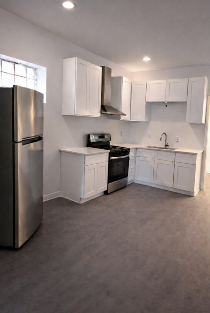 4519 West Thomas Street, Unit 1 Chicago, IL 60651 - Photo 5 of 6 a kitchen with stainless steel appliances granite countertop a refrigerator a stove a sink and white cabinets