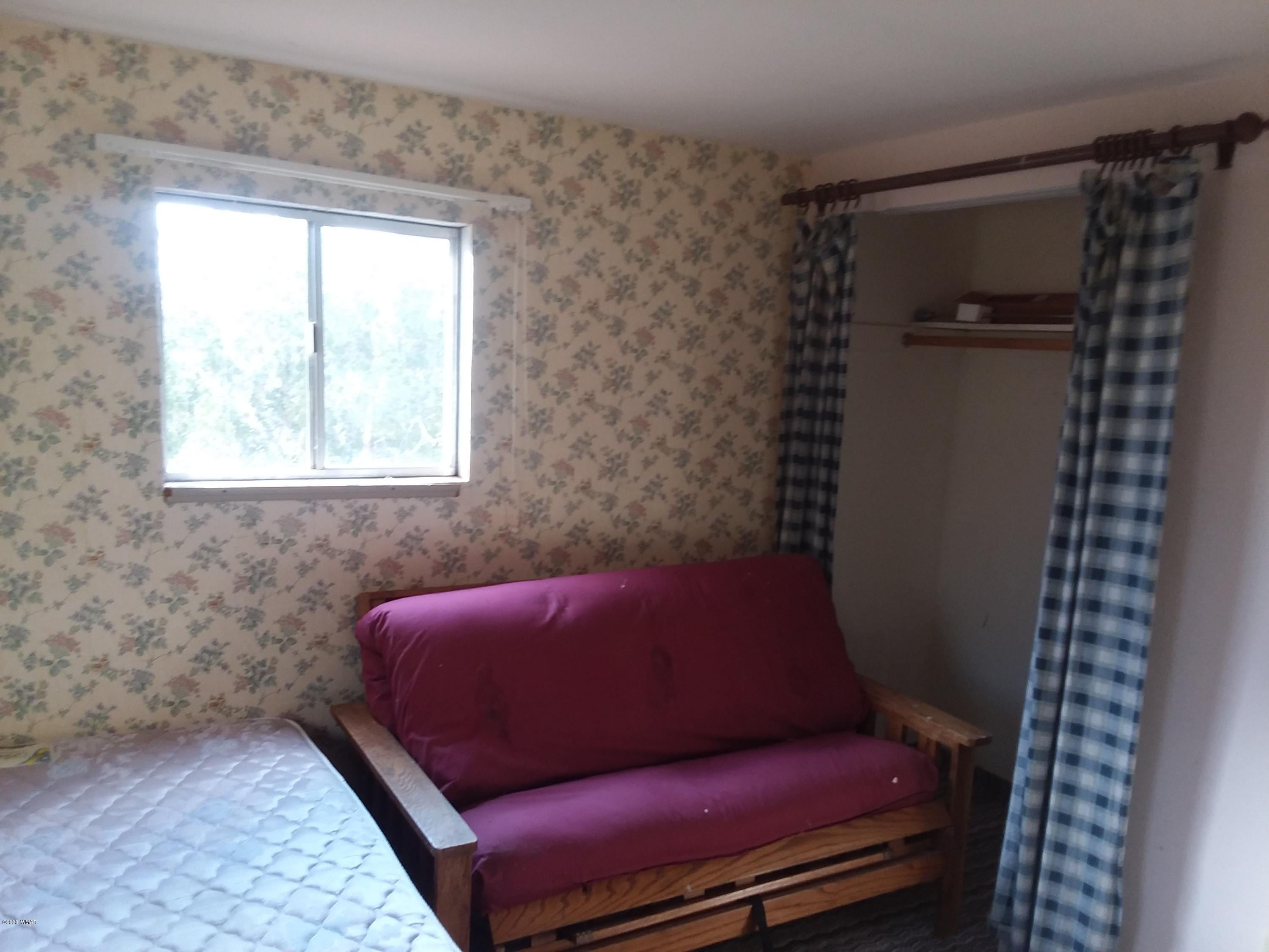 Lot 361 Woodridge Ranch, Unit 9 Concho, AZ 85924 - Photo 8 of 22 a couch sitting in a bedroom next to a window