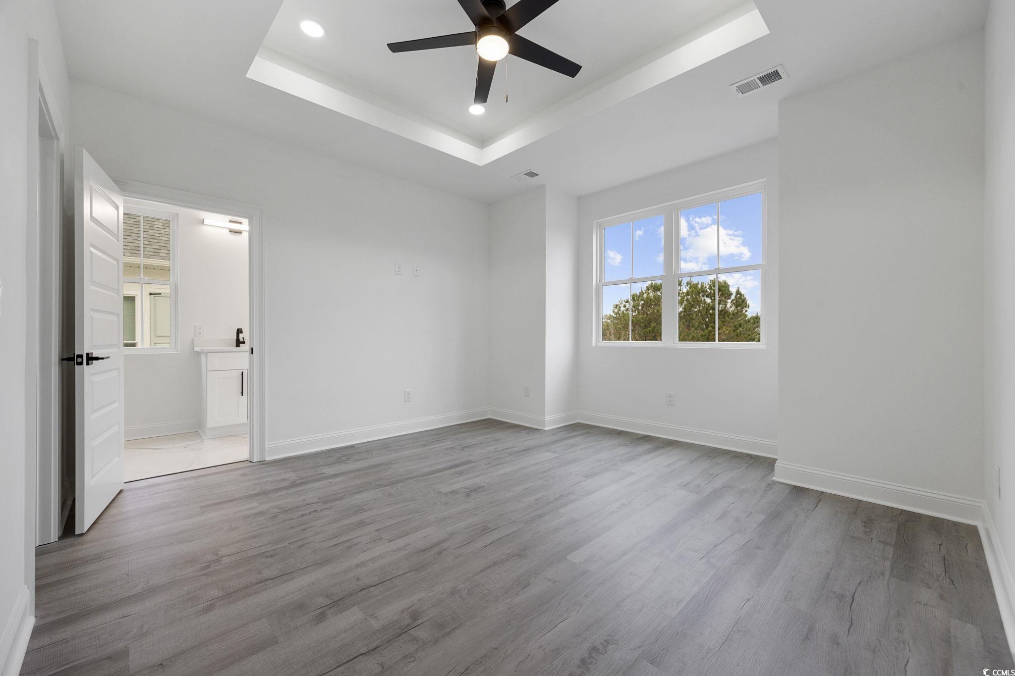 514 Harbour View Drive Myrtle Beach, SC 29579 - Photo 14 of 40 Unfurnished bedroom with light wood-style flooring, a tray ceiling, a ceiling fan, recessed lighting, and ensuite bath