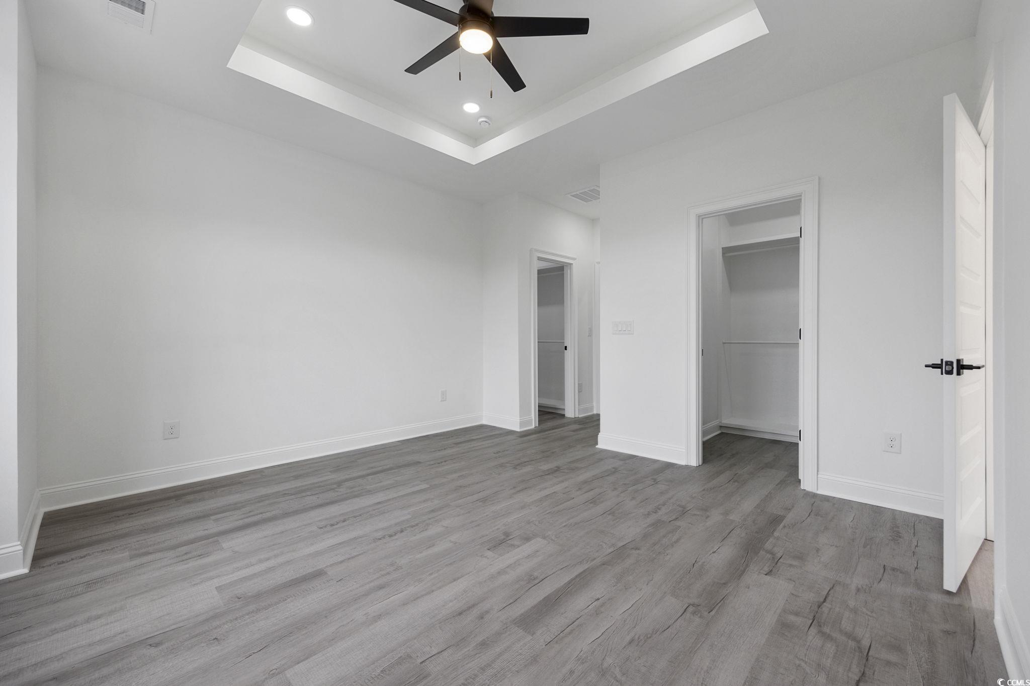 514 Harbour View Drive Myrtle Beach, SC 29579 - Photo 15 of 40 Unfurnished bedroom featuring a raised ceiling, light wood-type flooring, a spacious closet, ceiling fan, and recessed lighting