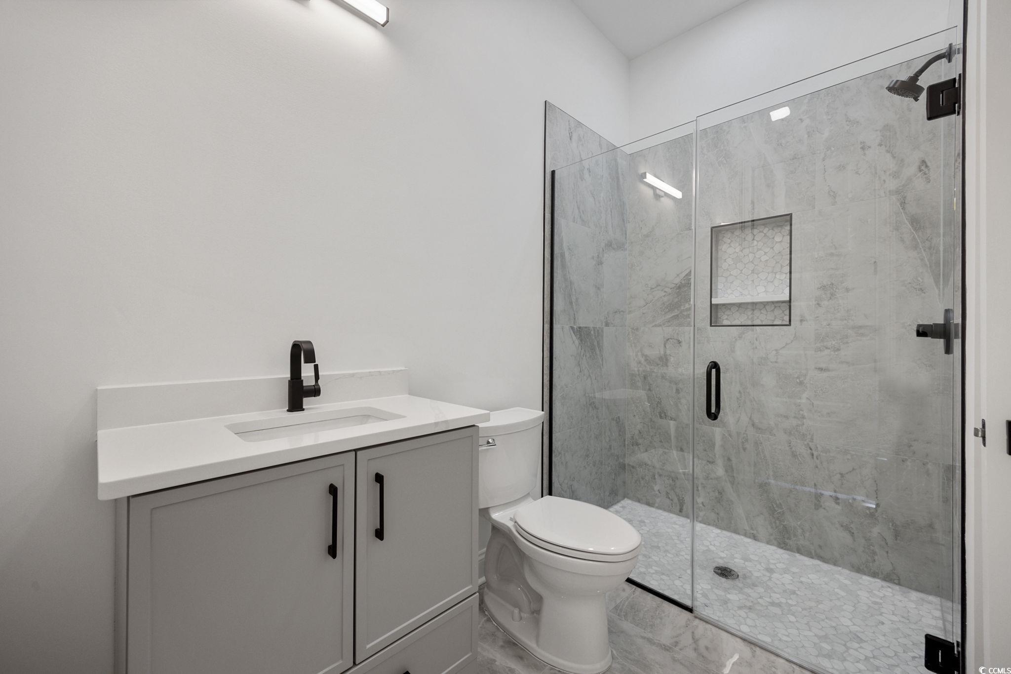 514 Harbour View Drive Myrtle Beach, SC 29579 - Photo 23 of 40 Bathroom with vanity, marble look tiles, and a marble finish shower