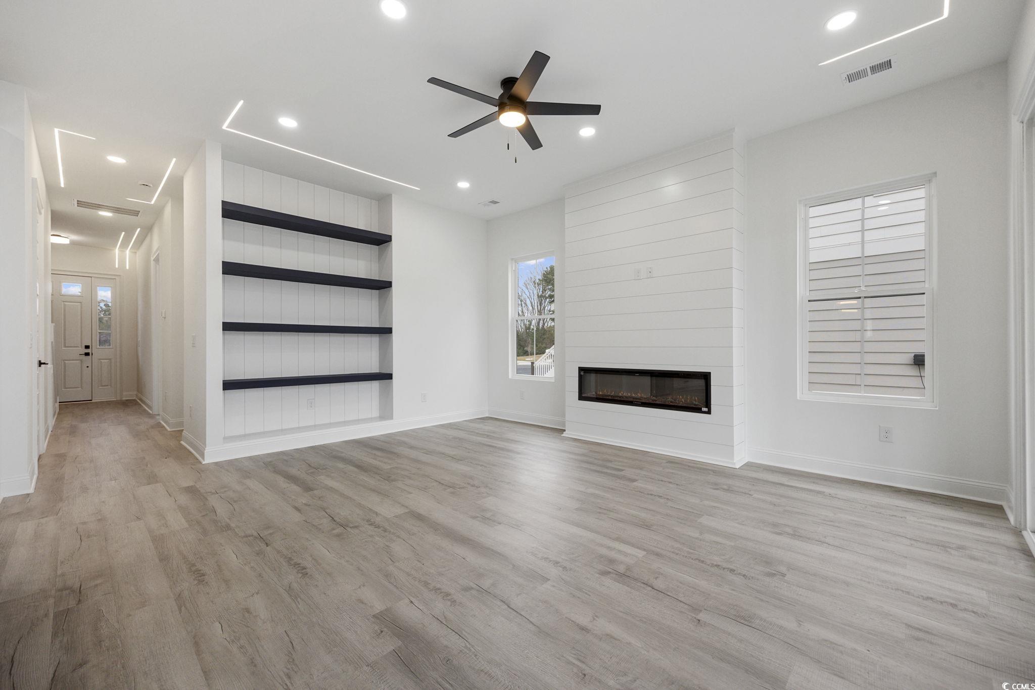 514 Harbour View Drive Myrtle Beach, SC 29579 - Photo 6 of 40 Unfurnished living room featuring built in features, light wood finished floors, ceiling fan, a large fireplace, and recessed lighting