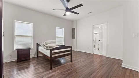 a bedroom with a bed and wooden floor