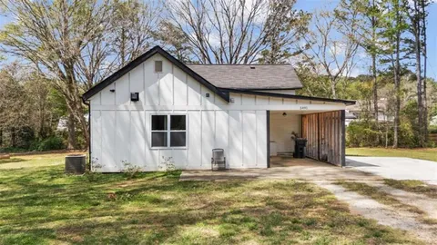 a view of a house with backyard and tree