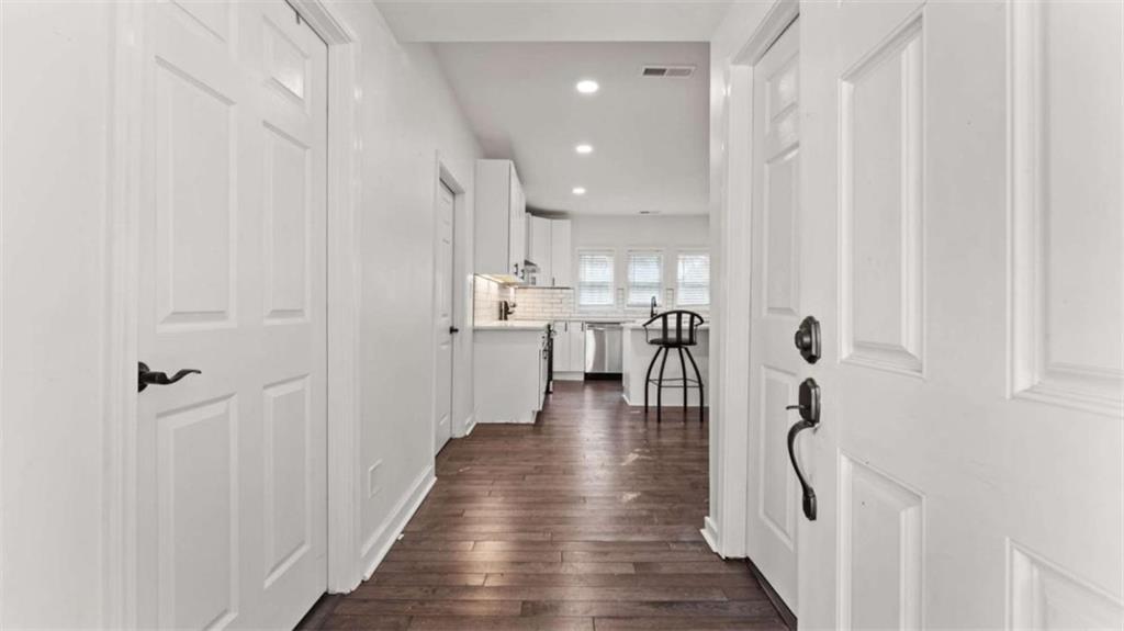 5491 Hill Road Southwest Powder Springs, GA 30127 - Photo 6 of 22 a view of a hallway with wooden floor windows and a kitchen view