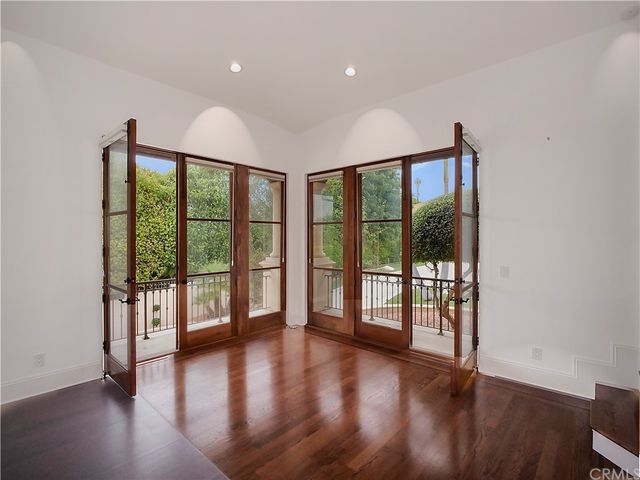 a bedroom with a bed mirror on dresser and a chandelier