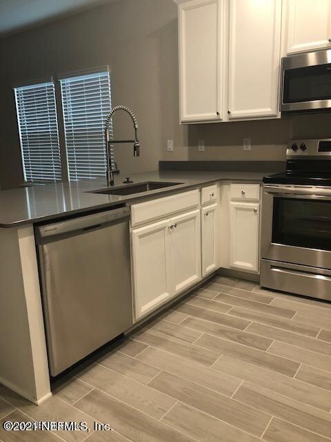 2565 Sandy Dune Drive Jacksonville, FL 32233 - Photo 4 of 14 a kitchen with granite countertop cabinets stainless steel appliances and a sink