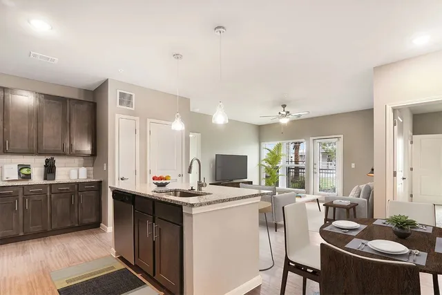 a kitchen with a stove a sink a dining table and chairs