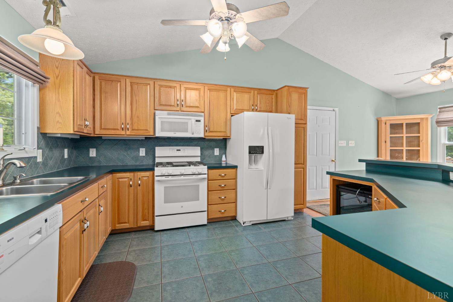 298 Braxton Ridge Road Amherst, VA 24521 - Photo 7 of 65 a kitchen with stainless steel appliances granite countertop a refrigerator a sink dishwasher a stove with wooden cabinets and floor