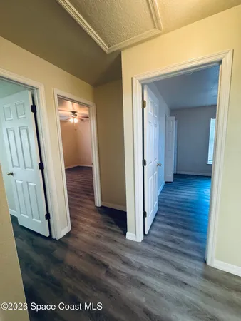 a view of a hallway with wooden floor and staircase