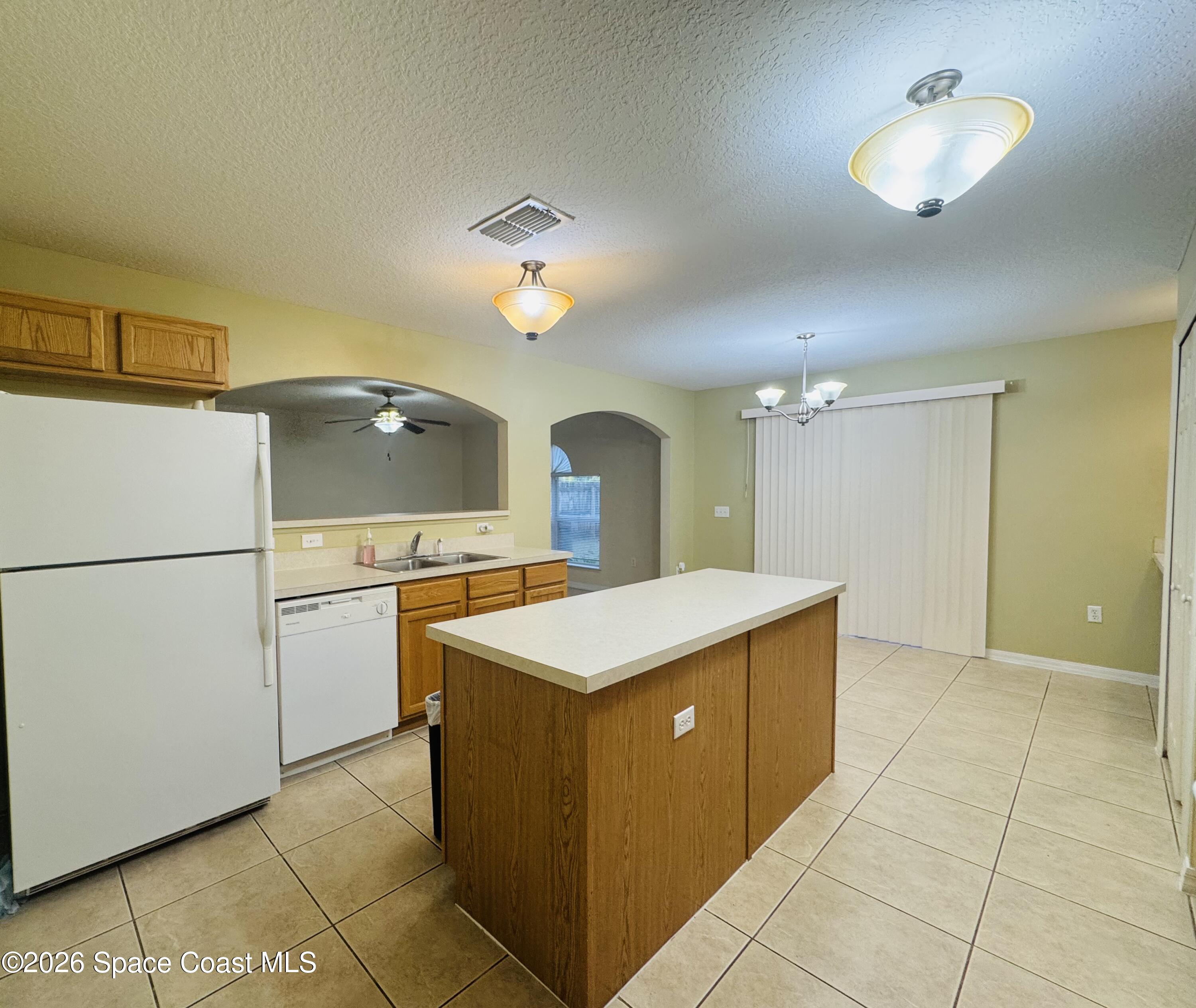 4550 Elena Way Melbourne, FL 32934 - Photo 6 of 33 a kitchen with a cabinets and chandelier