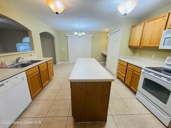 a kitchen with a sink a stove top oven and cabinets