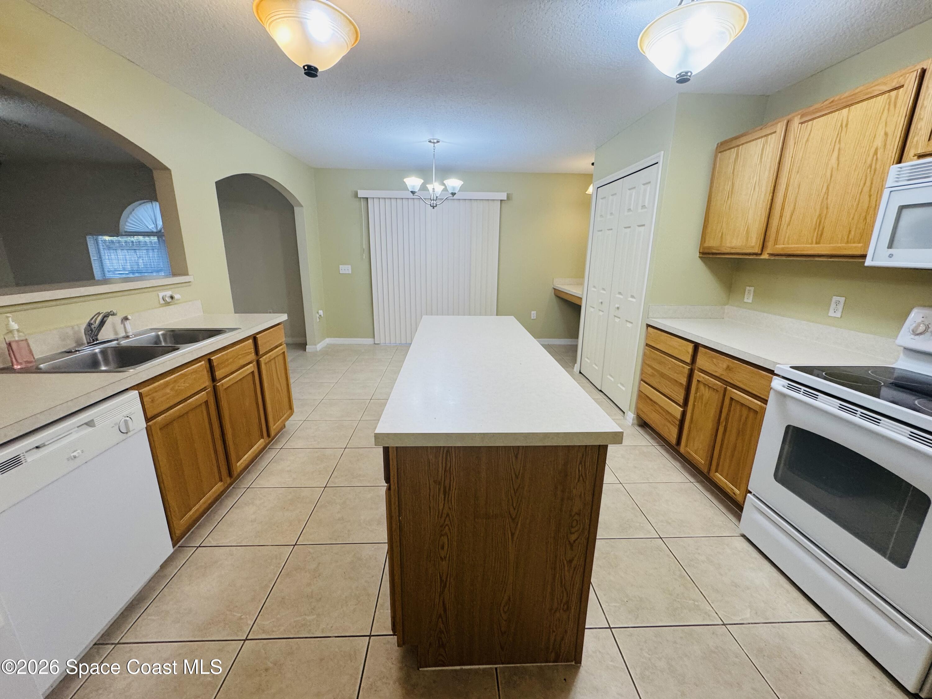 4550 Elena Way Melbourne, FL 32934 - Photo 7 of 33 a kitchen with a sink a stove top oven and cabinets