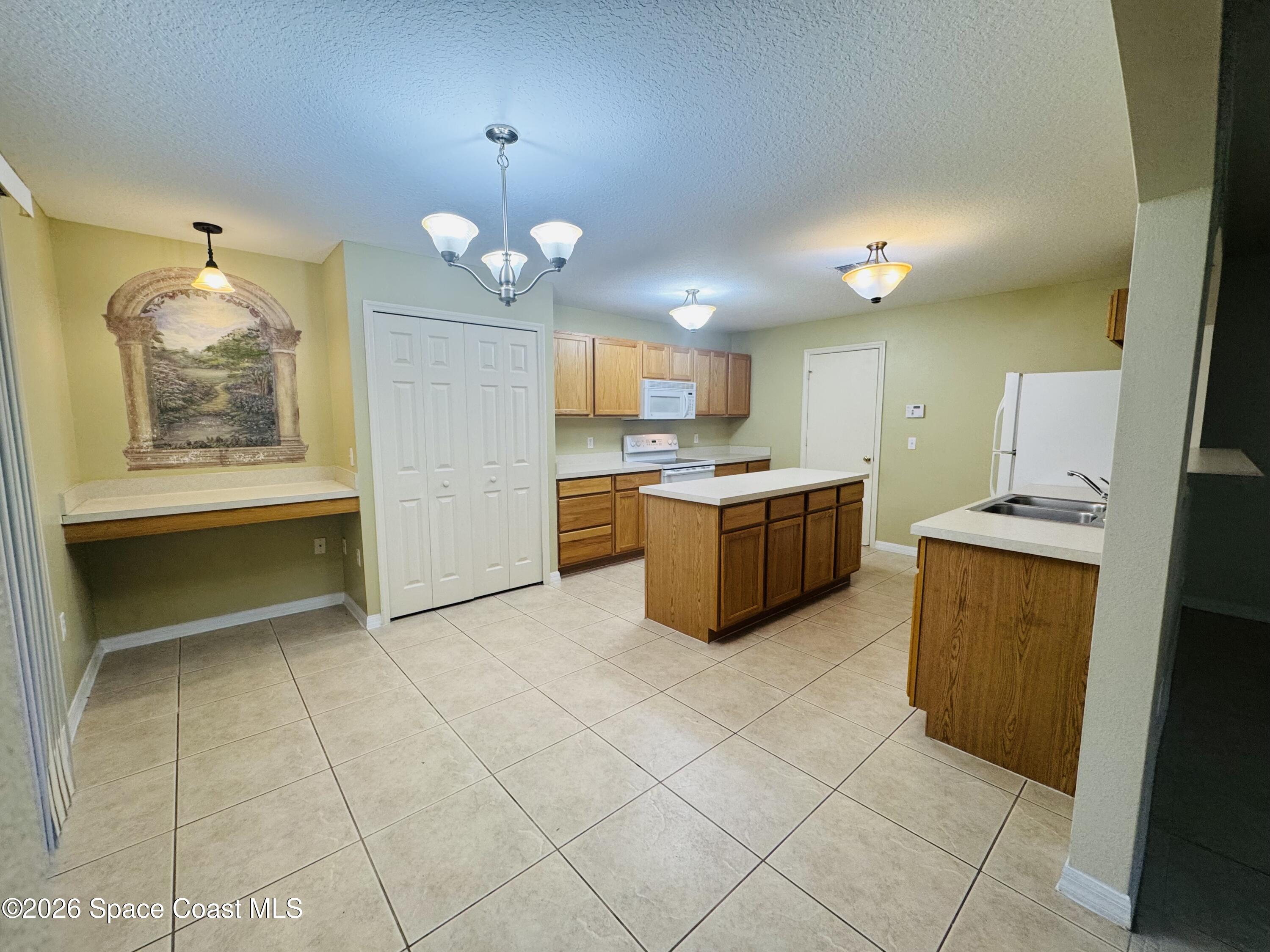 4550 Elena Way Melbourne, FL 32934 - Photo 9 of 33 a kitchen with cabinets and window