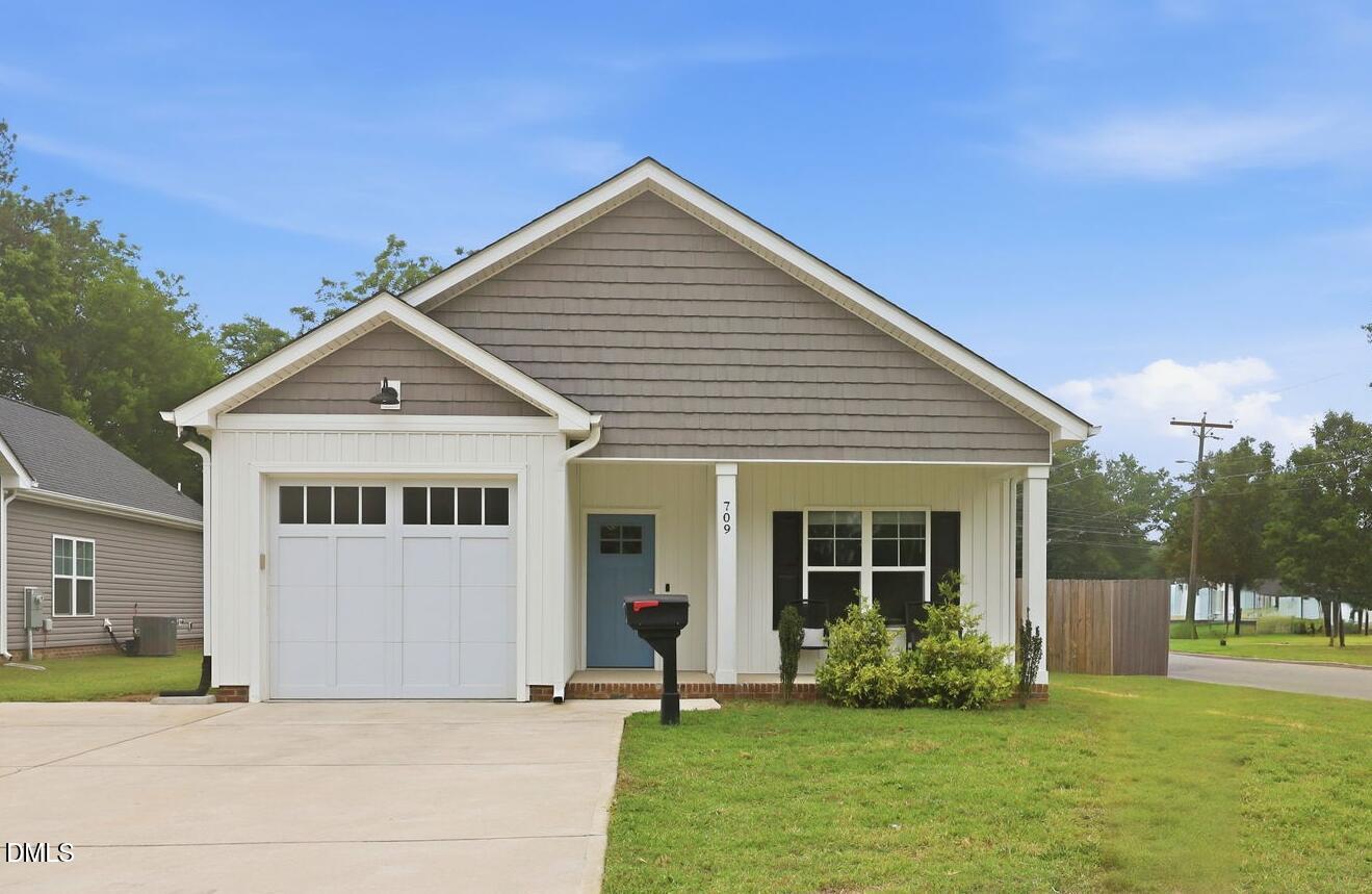 709 South Pollock Street Selma, NC 27576 - Photo 1 of 30 a front view of a house with a yard and garage