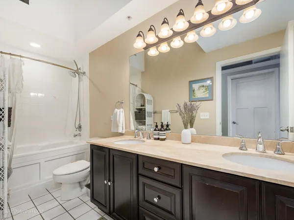 a bathroom with a sink a toilet and a large mirror