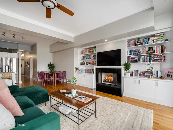 a living room with furniture a flat screen tv and a bookshelf