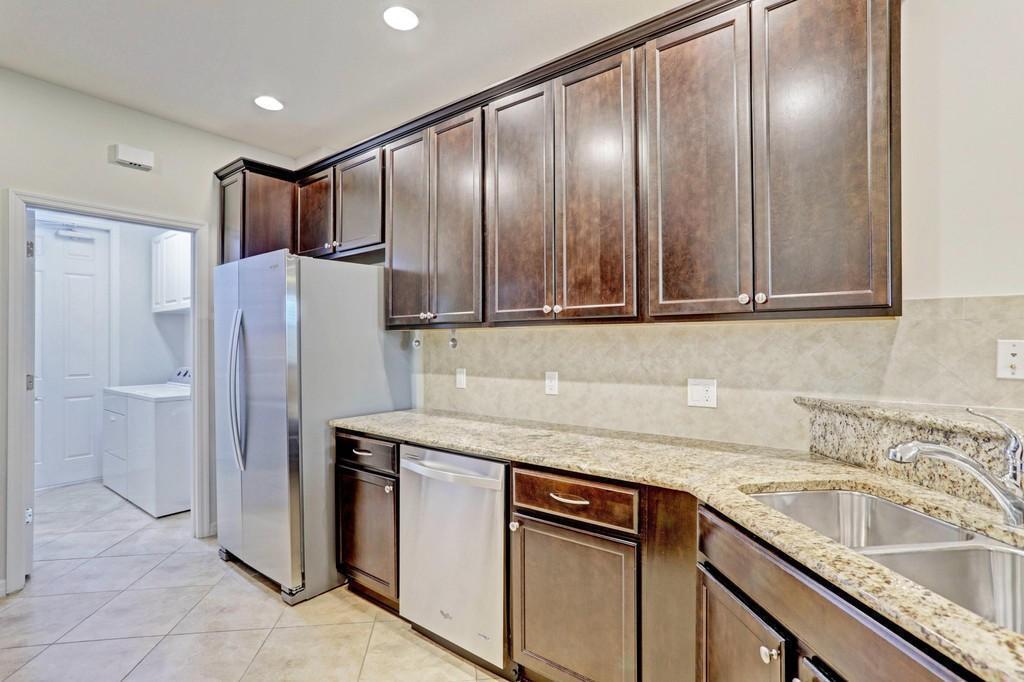 1132 South Community Drive Jupiter, FL 33458 - Photo 4 of 20 a kitchen with stainless steel appliances granite countertop cabinets and refrigerator